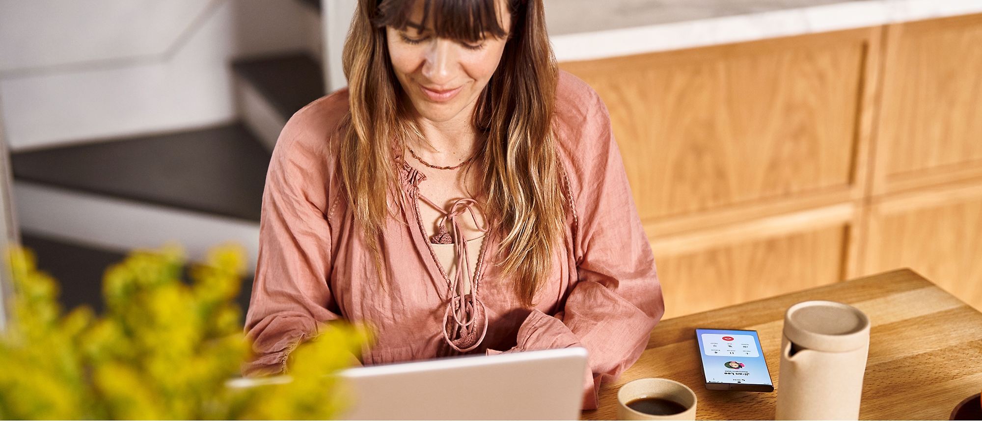 A woman sitting at a desk using a laptop.
