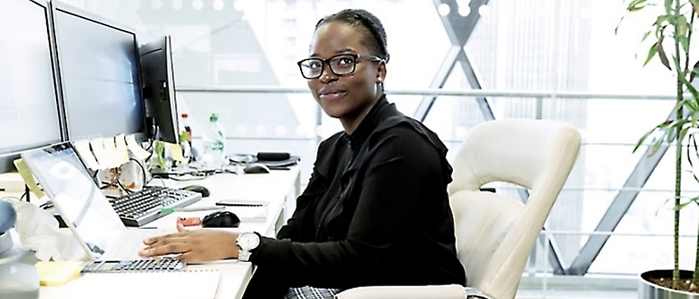 A person sitting at a desk and smiling.