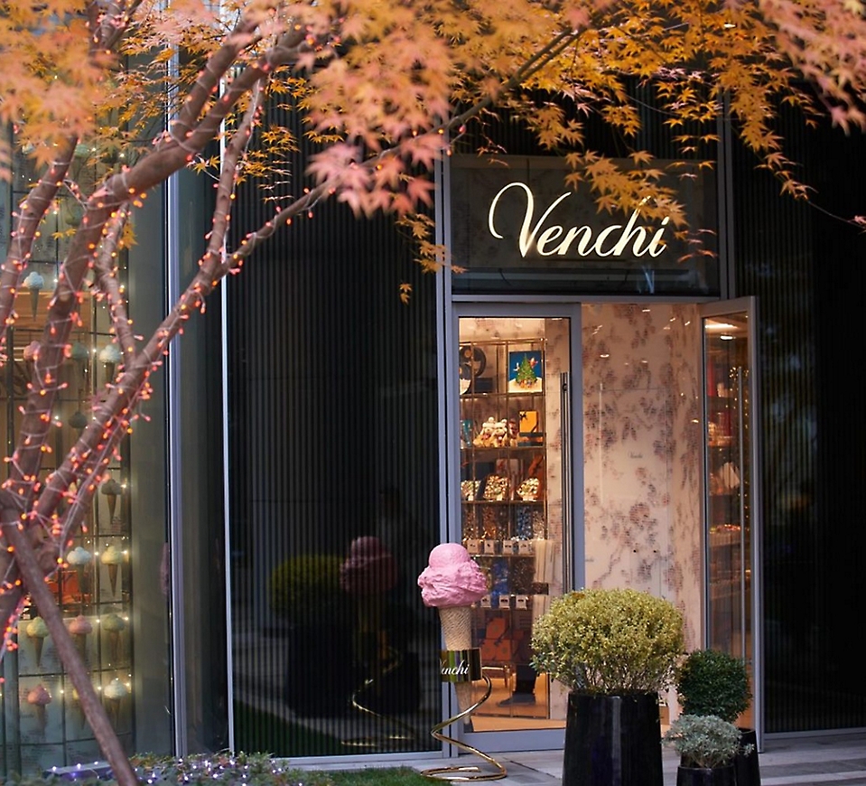 A storefront with a tree and the text Venchi.