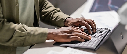 A person's hands typing on a keyboard.