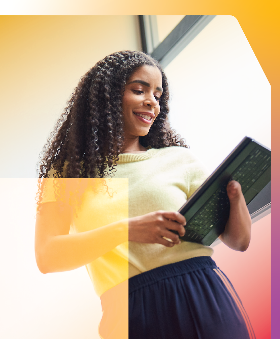 A woman with curly hair is holding a tablet.