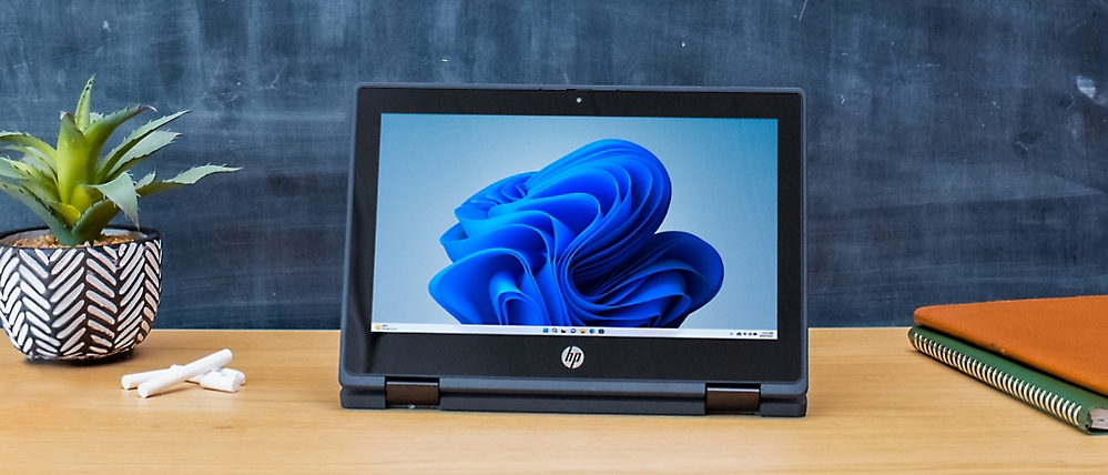 A laptop on a table with a blue object displayed on the screen.
