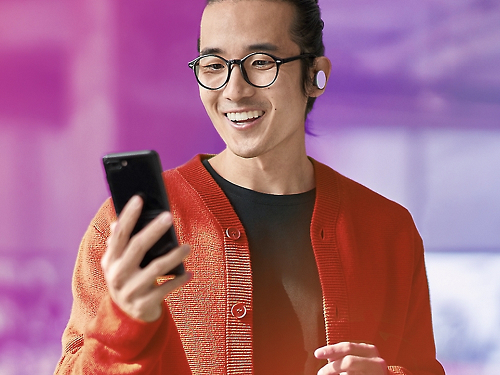 une personne regardant un mobile avec le sourire