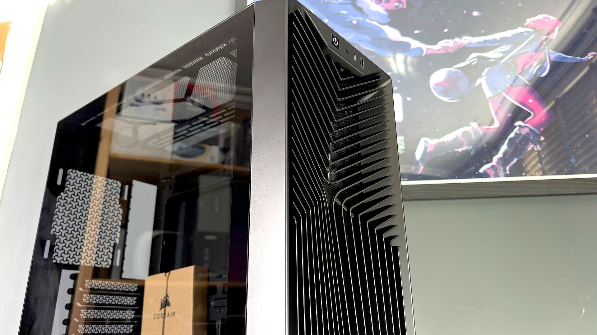 A Corsair PC case, the 3200D, on a desk with various panels removed and ready for a PC build.