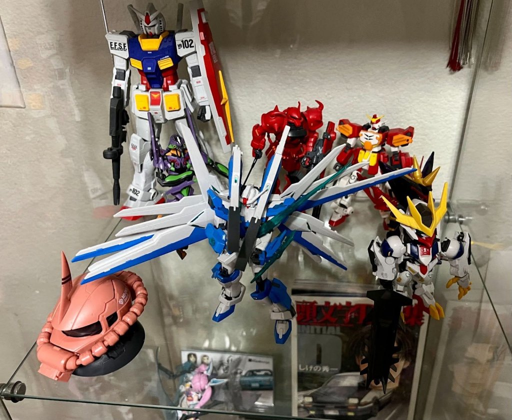 A photograph of several Gundam models on a shelf.