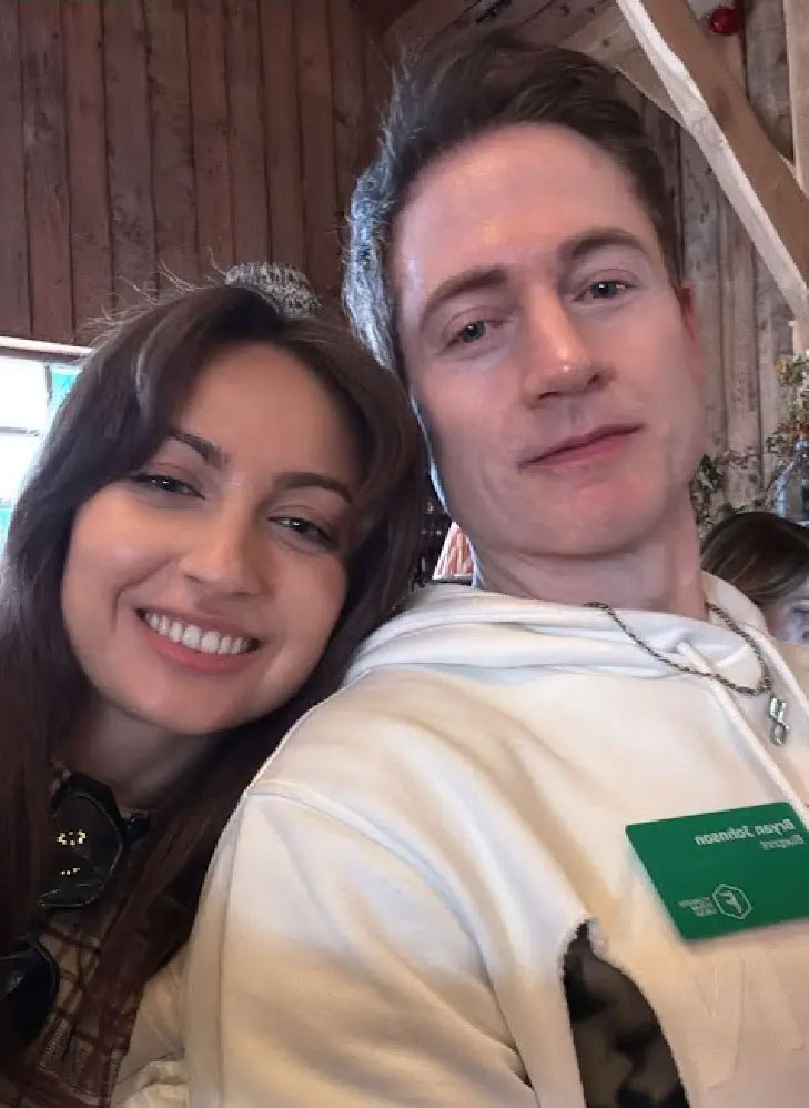 Kate Tolo smiling next to Bryan Johnson, who is wearing a nametag.